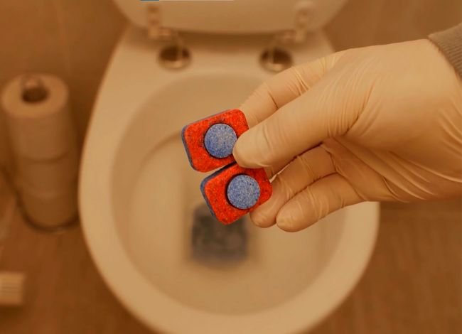 Applying a dishwasher tablet in the toilet is an easy process