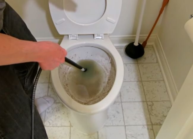 Using an auger for cleaning toilets